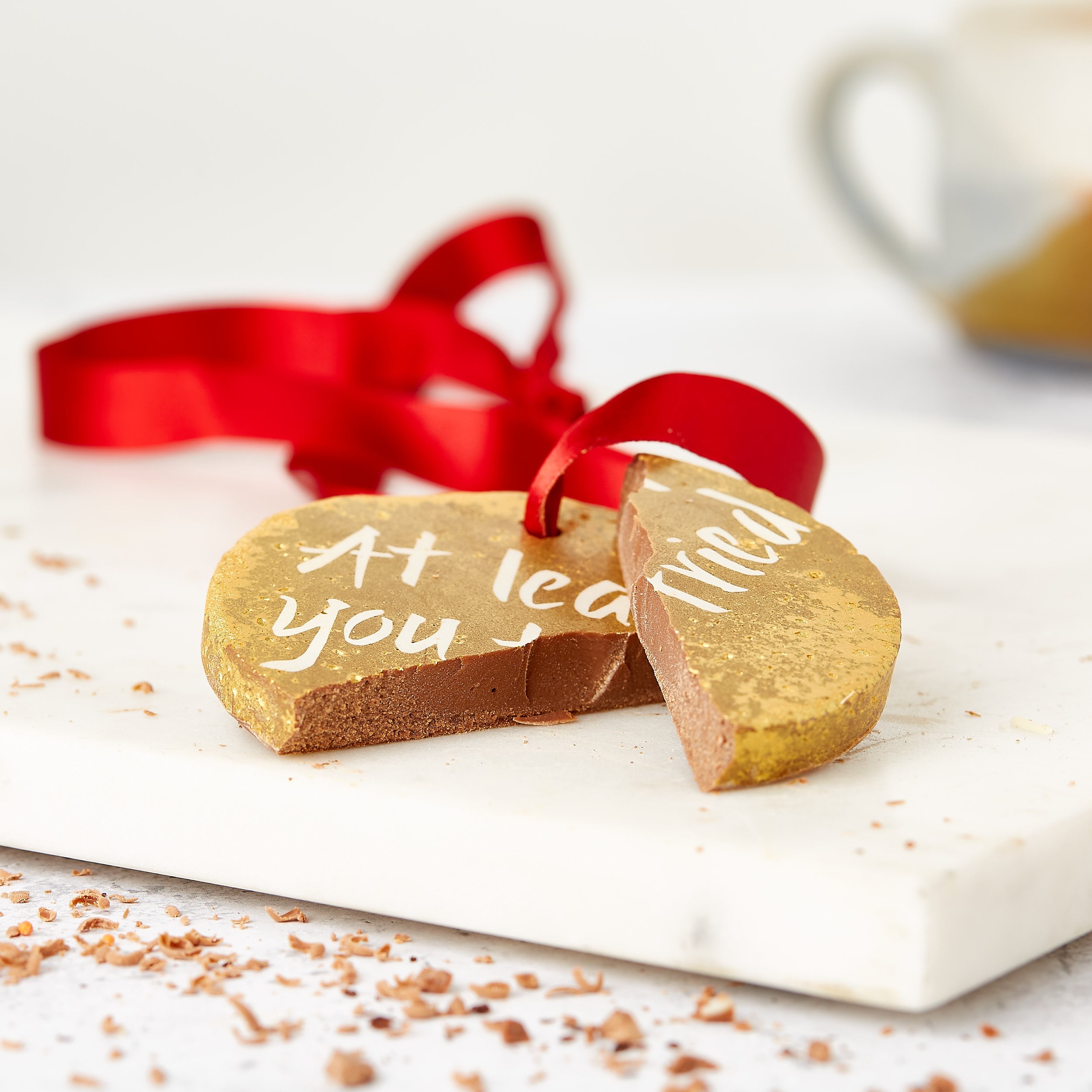A cheeky gold chocolate medal snapped in half, with the “At least you tried” message just visible on – one of those cheeky gifts that sweetens the blow with chocolate.