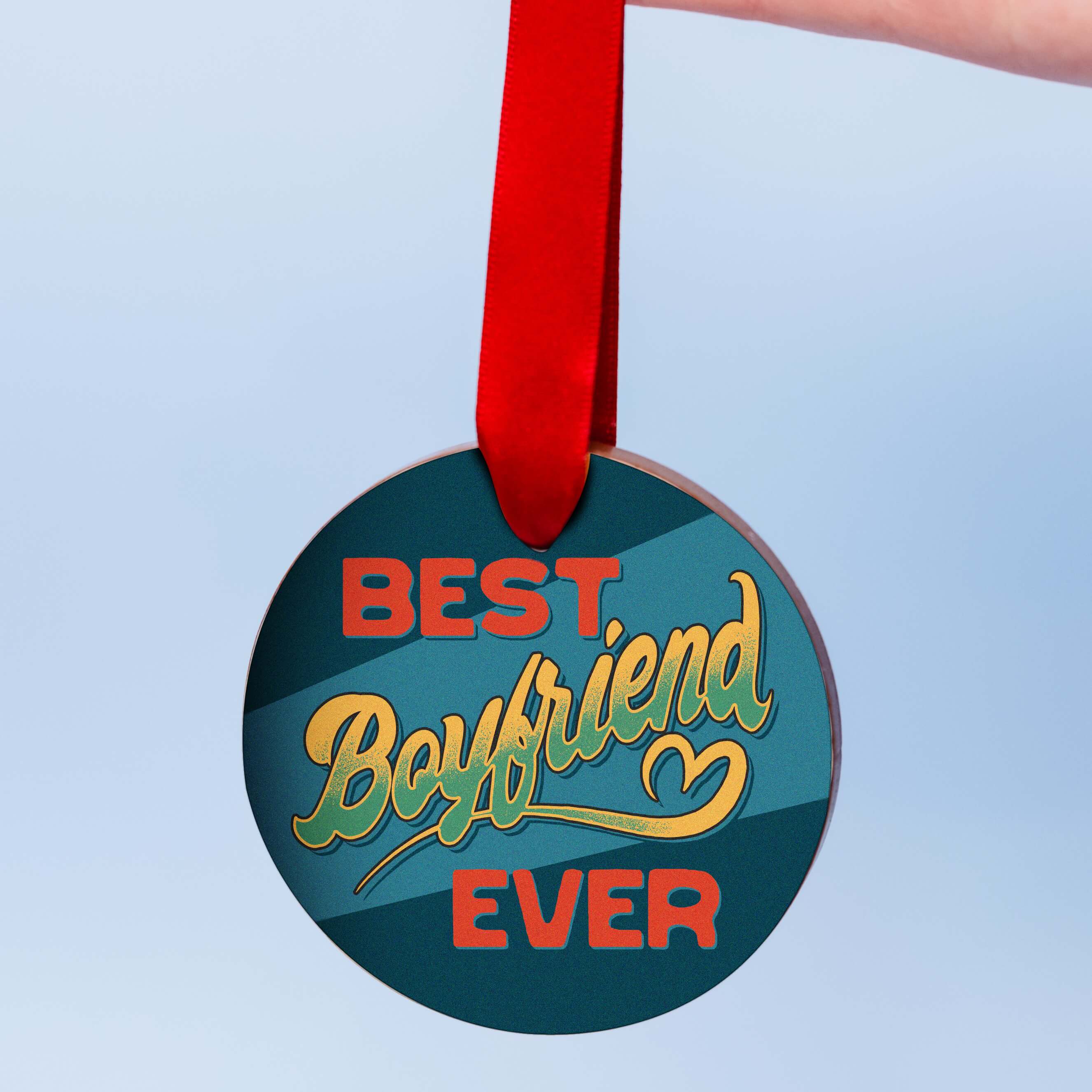 Funny valentines gift for boyfriend, a chunky milk chocolate medal with a colourful edible transfer reading “Best Boyfriend Ever”, hanging from a red ribbon against a pale blue background.