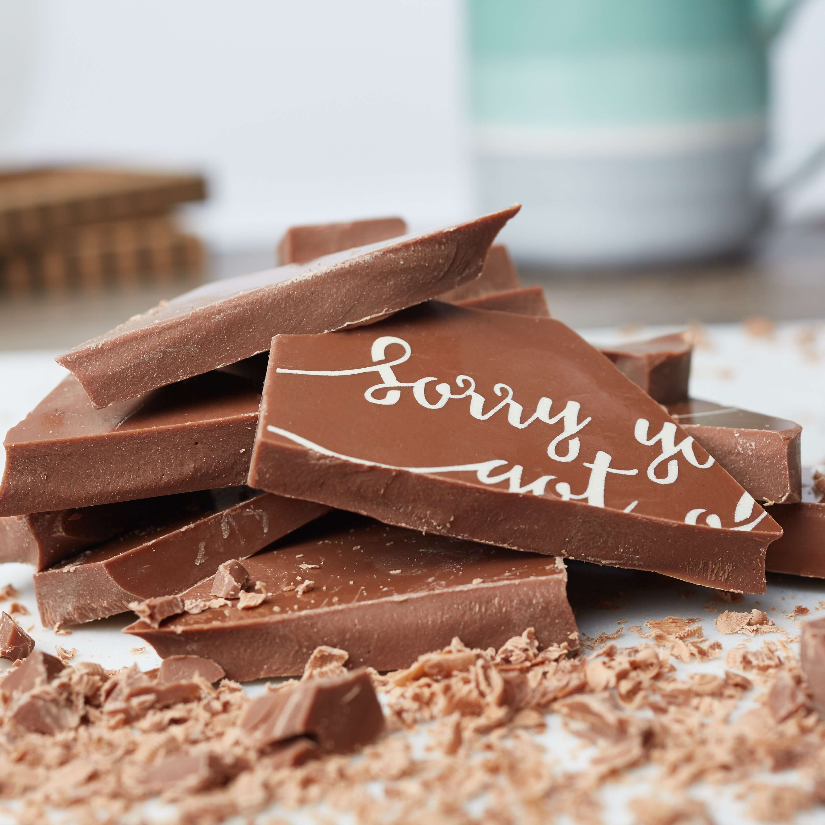 Chocolate for Birthdays - Close-up of solid Belgian chocolate chunks with ‘Sorry you got old’ written across the shards. Cheeky, delicious and ideal for a birthday roast.
