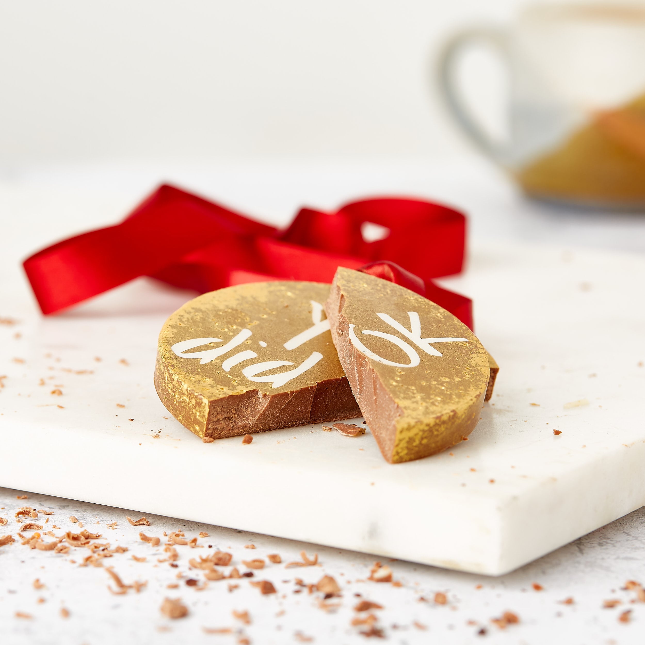 A "You did OK" chocolate medal snapped in half on a marble board, with red ribbon and chocolate shavings – a perfect pick for banter gifts that taste as good as they sass.
