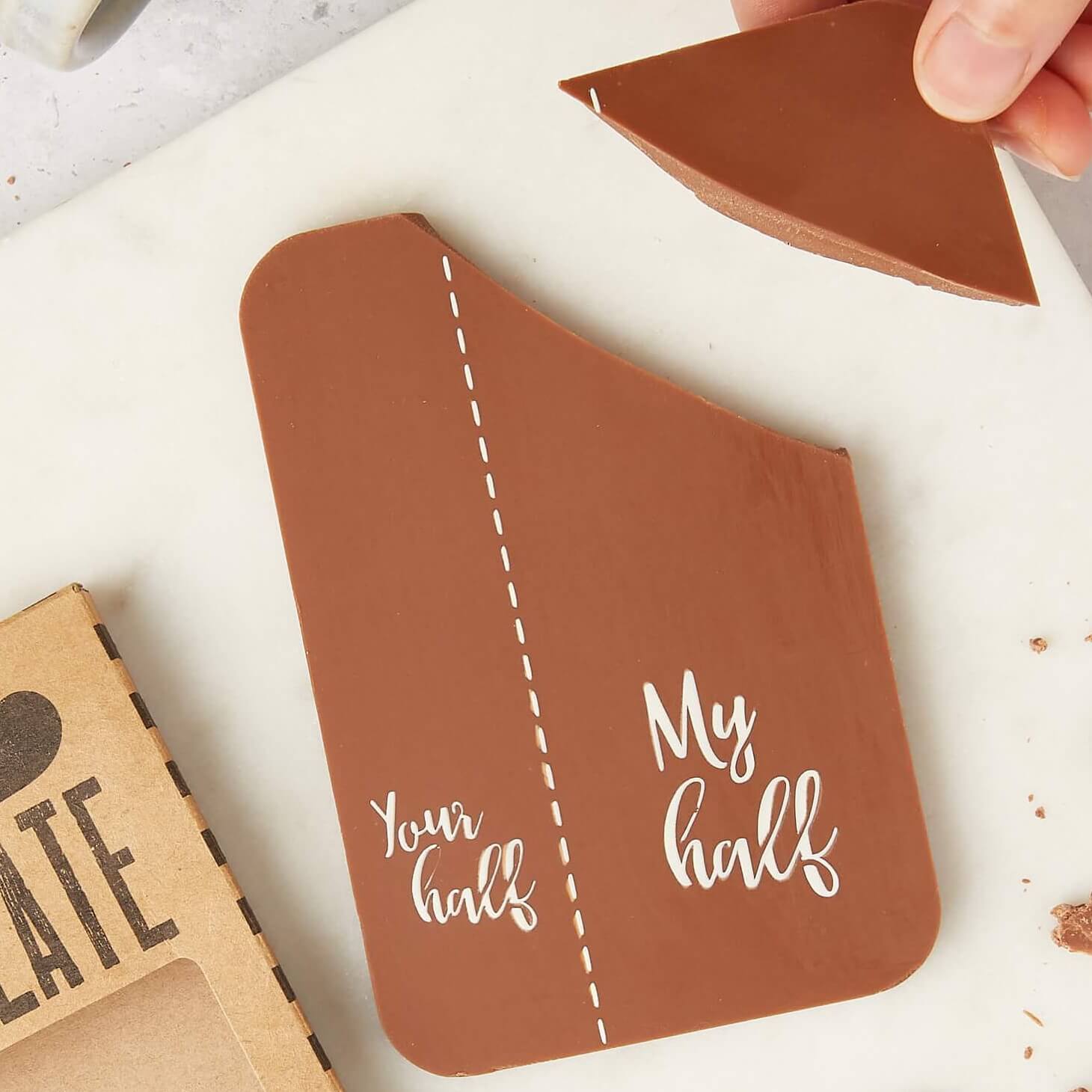 A chocolate bar with the words “Your half” and “My half” separated by a dotted line, with one piece being broken off — one of our most popular edible gifts by post for people who love chocolate, but not sharing.