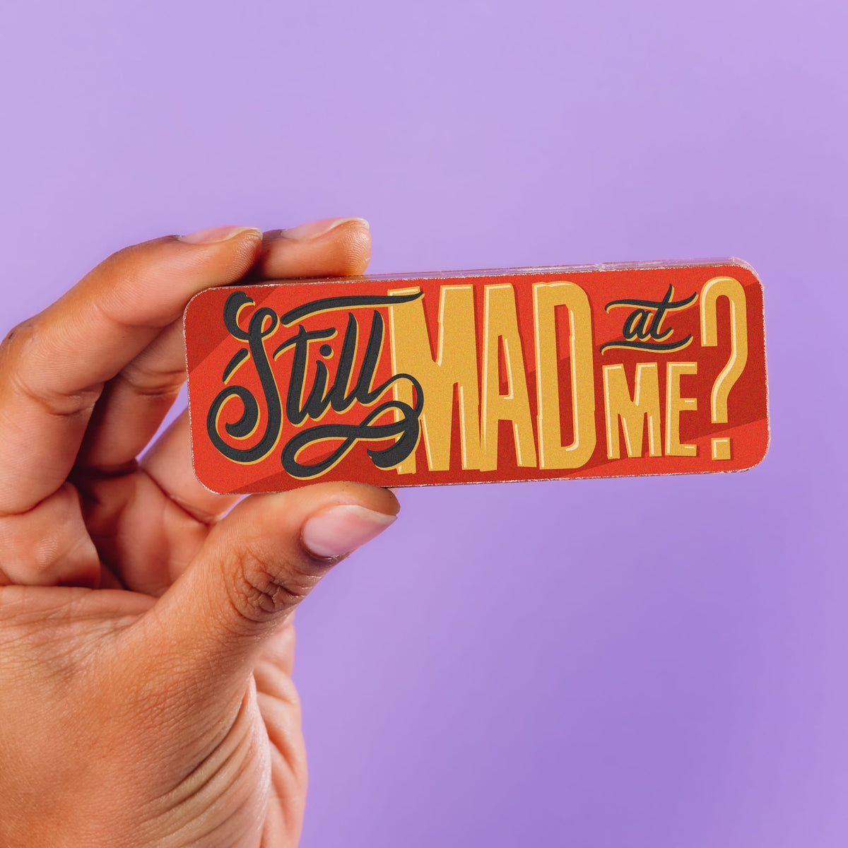 A colourfully decorated chocolate bar with a 'Still mad at me?' slogan being held up.  Part of the Sorry Chocolate Selection Box.