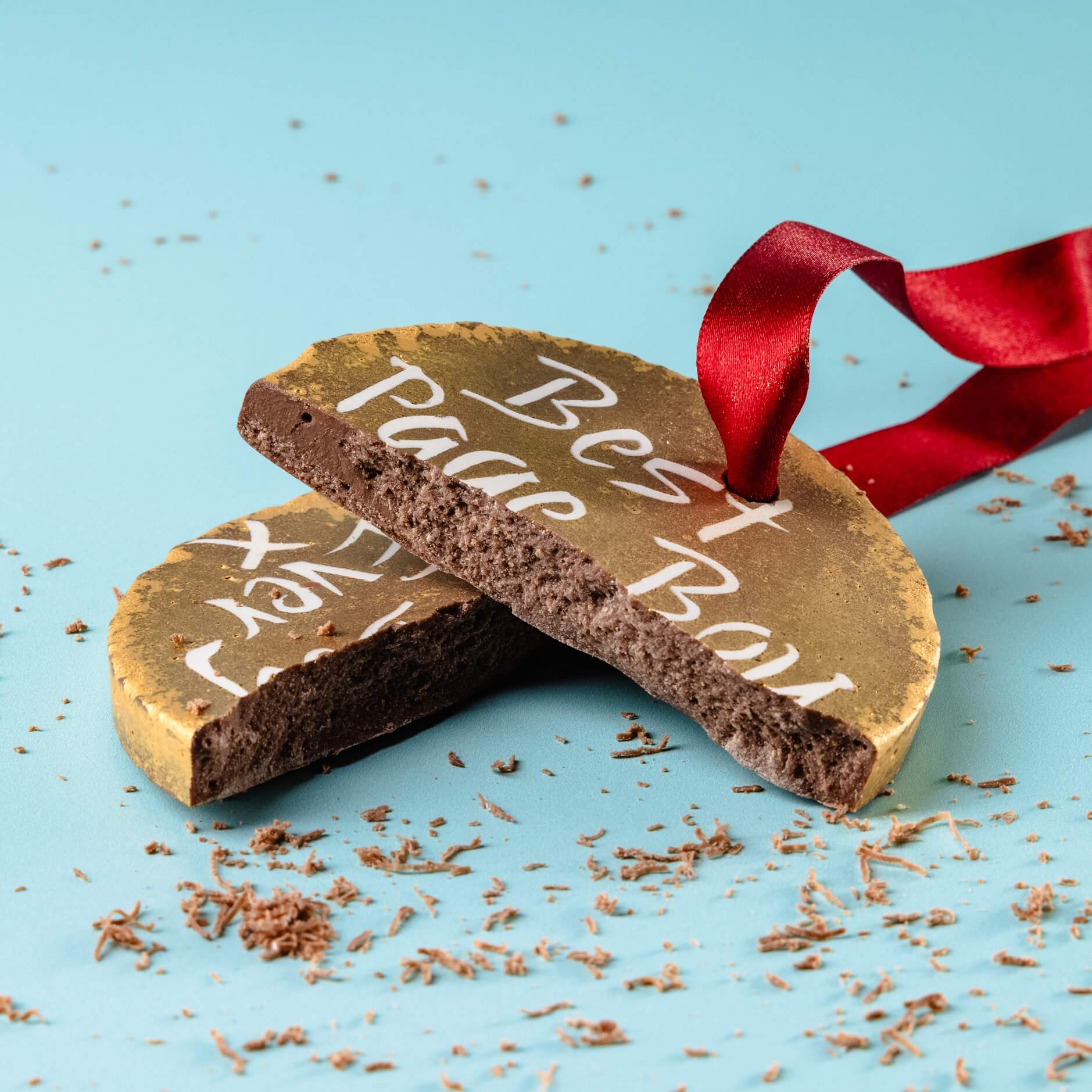 Broken chocolate medal showing “Best Page Boy Ever” message, surrounded by chocolate shavings – a sweet and playful page boy thank you gift that’s made to be devoured.