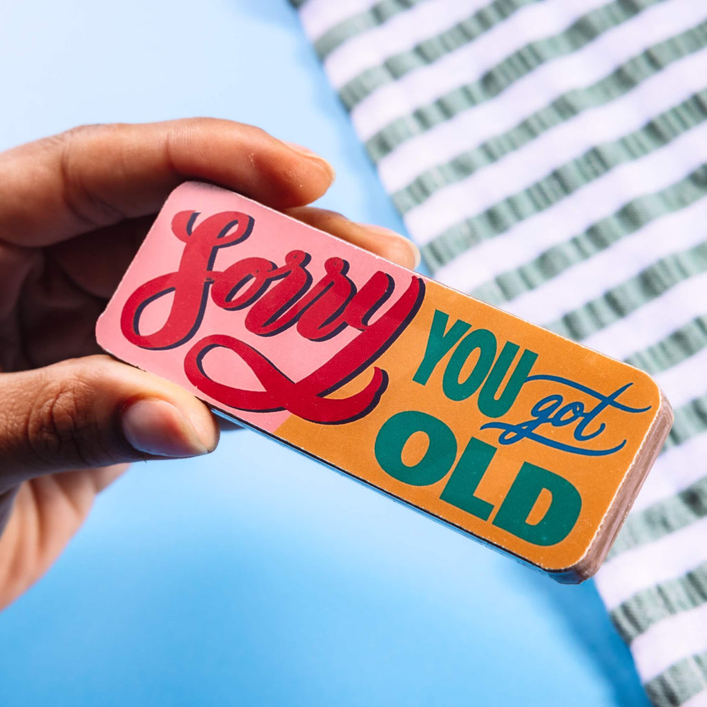 Close-up of a hand holding a chocolate bar with a transfer that reads “Sorry You Got Old”.  Absolutely the best birthday gifts for girlfriends with a sense of humour.