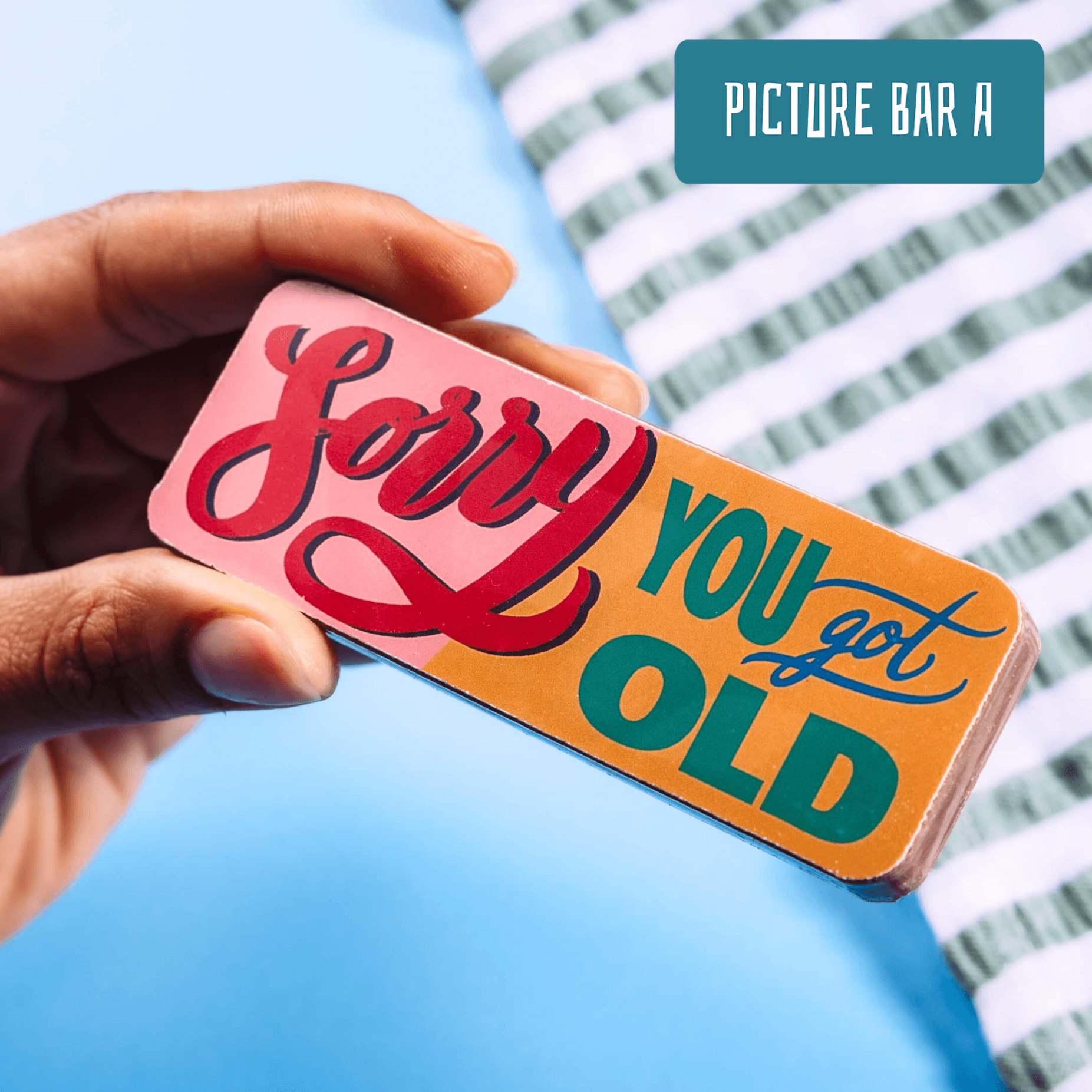 Close-up of a hand holding a chocolate bar with a transfer that reads “Sorry You Got Old”.  Absolutely the best birthday gifts for girlfriends with a sense of humour.
