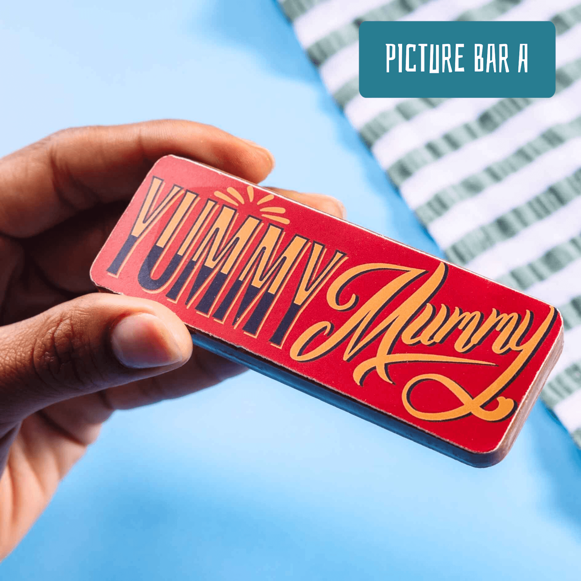 A close-up of a red and gold chocolate bar reading “Yummy Mummy” in retro-style typography. From our range of funny gifts for mum UK.