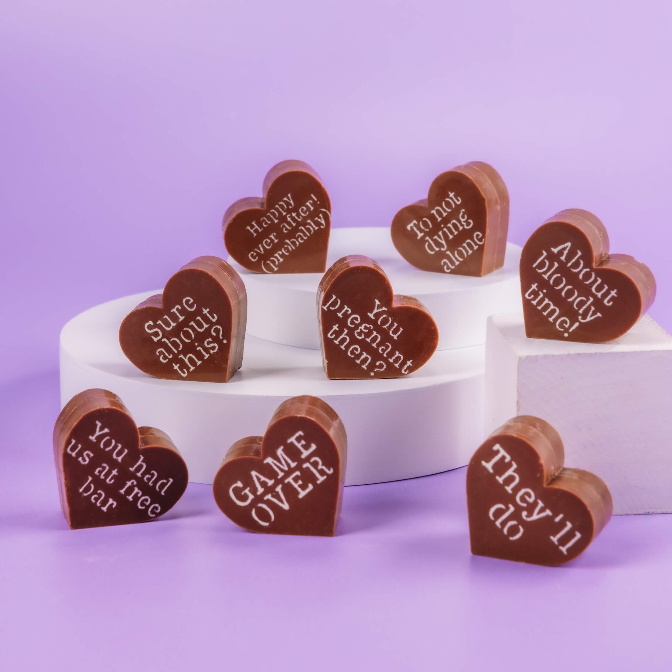 Heart-shaped Bagstock & Bumble engagement chocolates on plinths, featuring cheeky engraved slogans like 'Game over', a brilliant engagement gift for couples who love a bit of banter.