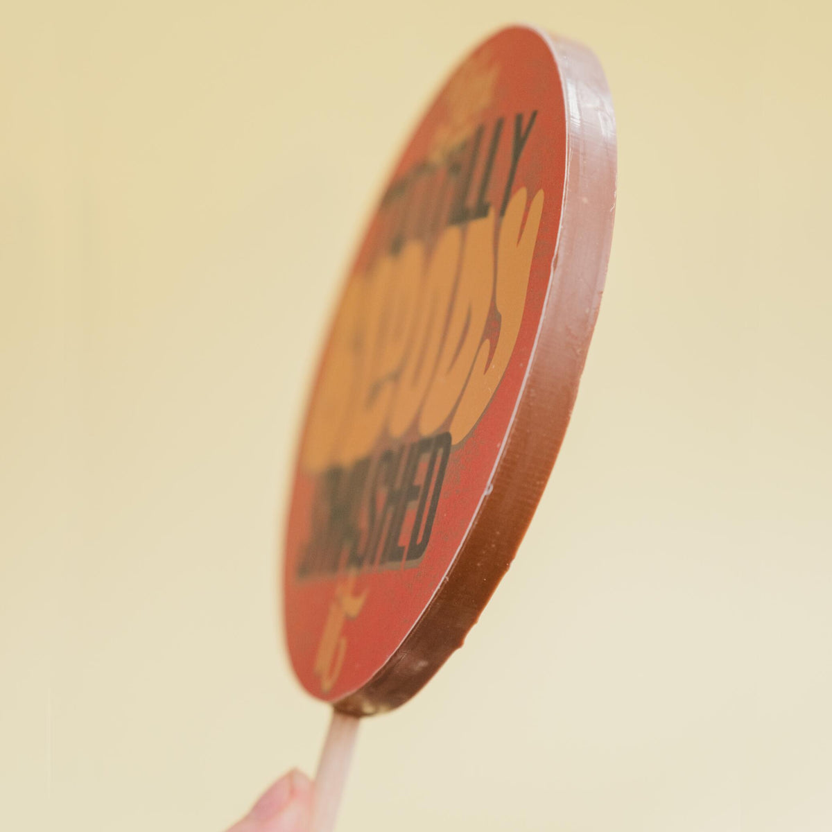 One of our jumbo milk chocolate lollies photographed from the size to show the thickness of the chocolate body