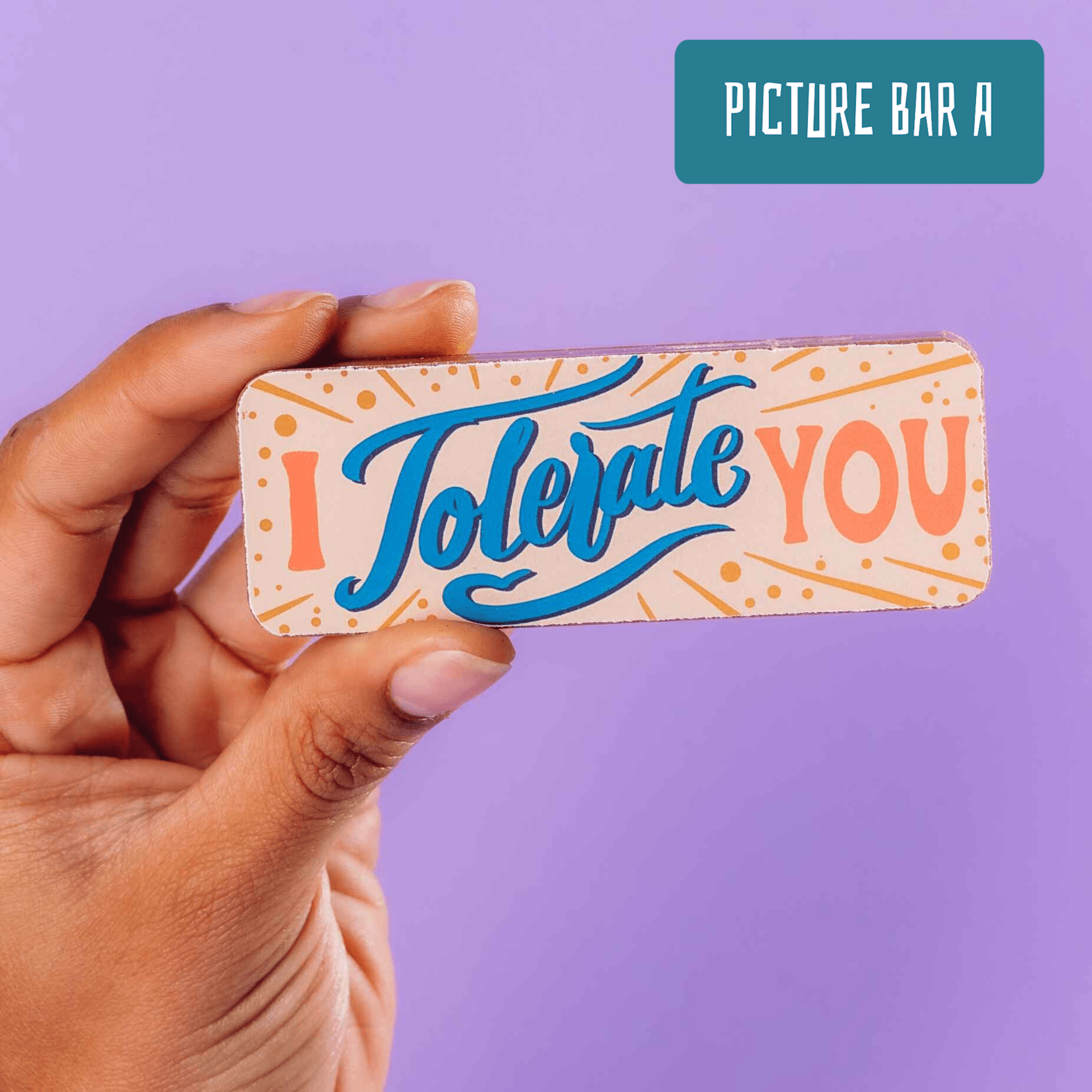 Close-up of a hand holding a chocolate bar that reads “I Tolerate You” in bold, playful lettering – an ideal option for funny anniversary gifts with low-key affection.