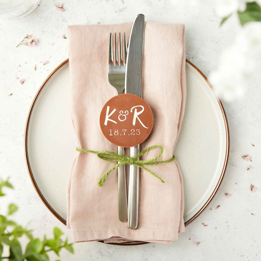 Place setting with with a custom chocolate showing the couple's initials and the date of the wedding