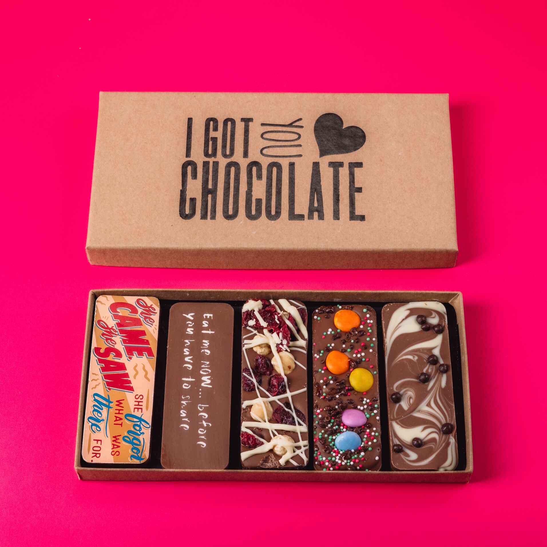 An open “I Got You Chocolate” gift box containing five treat-sized chocolate bars with playful slogans and scrummy toppings. Perfect gifts for menopausal women who need a laugh and a nibble.