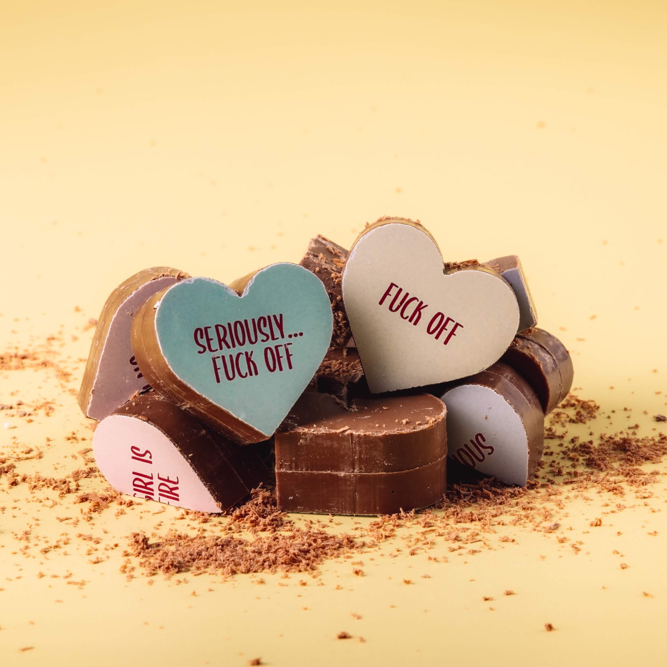 Broken pieces of Bagstock & Bumble menopause chocolates, highlighting the thick, solid Fairtrade Belgian milk chocolate inside.