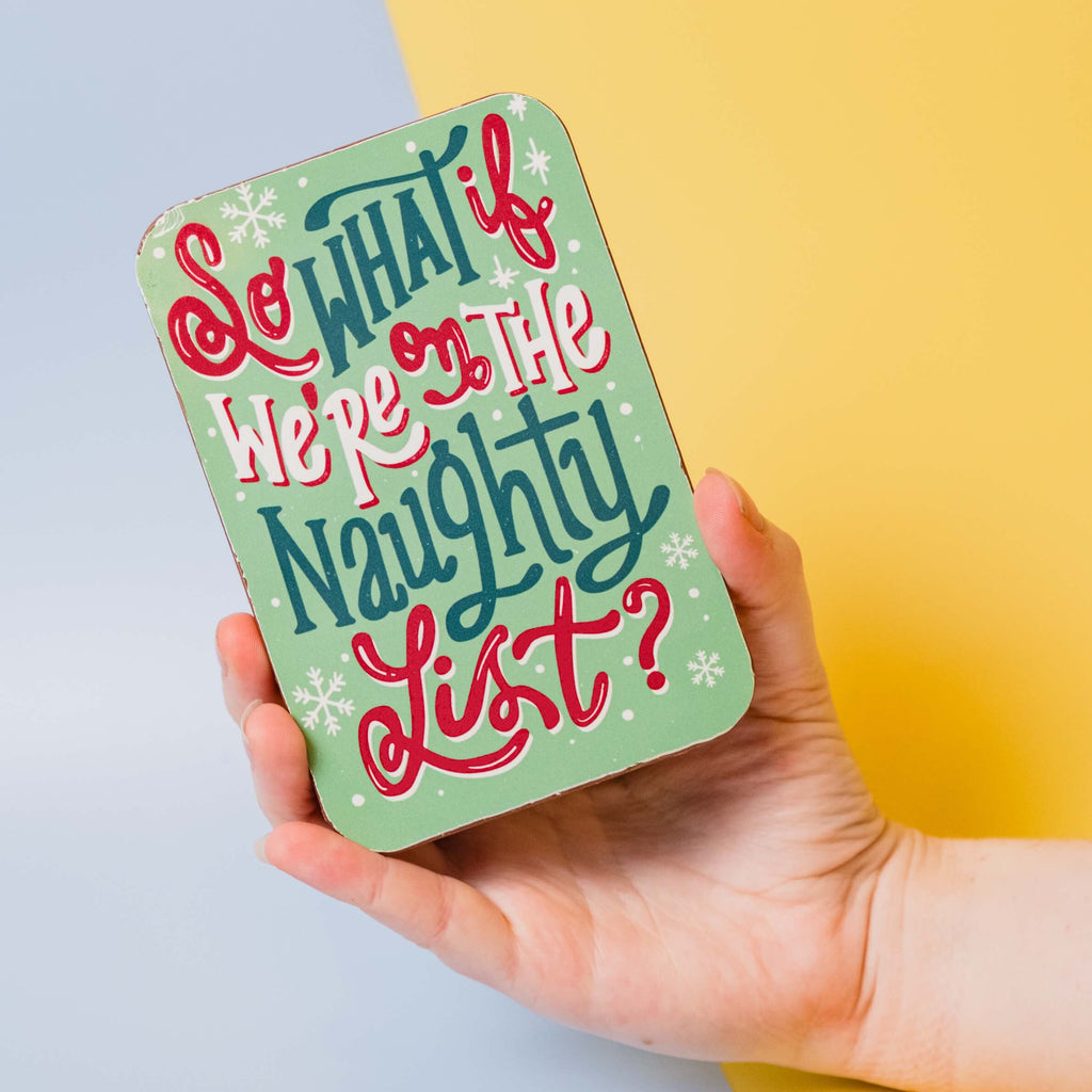 Chocolate bar being held up in front of a colourful background, decorated with a 'So What if We're on the Naughty List?' slogan