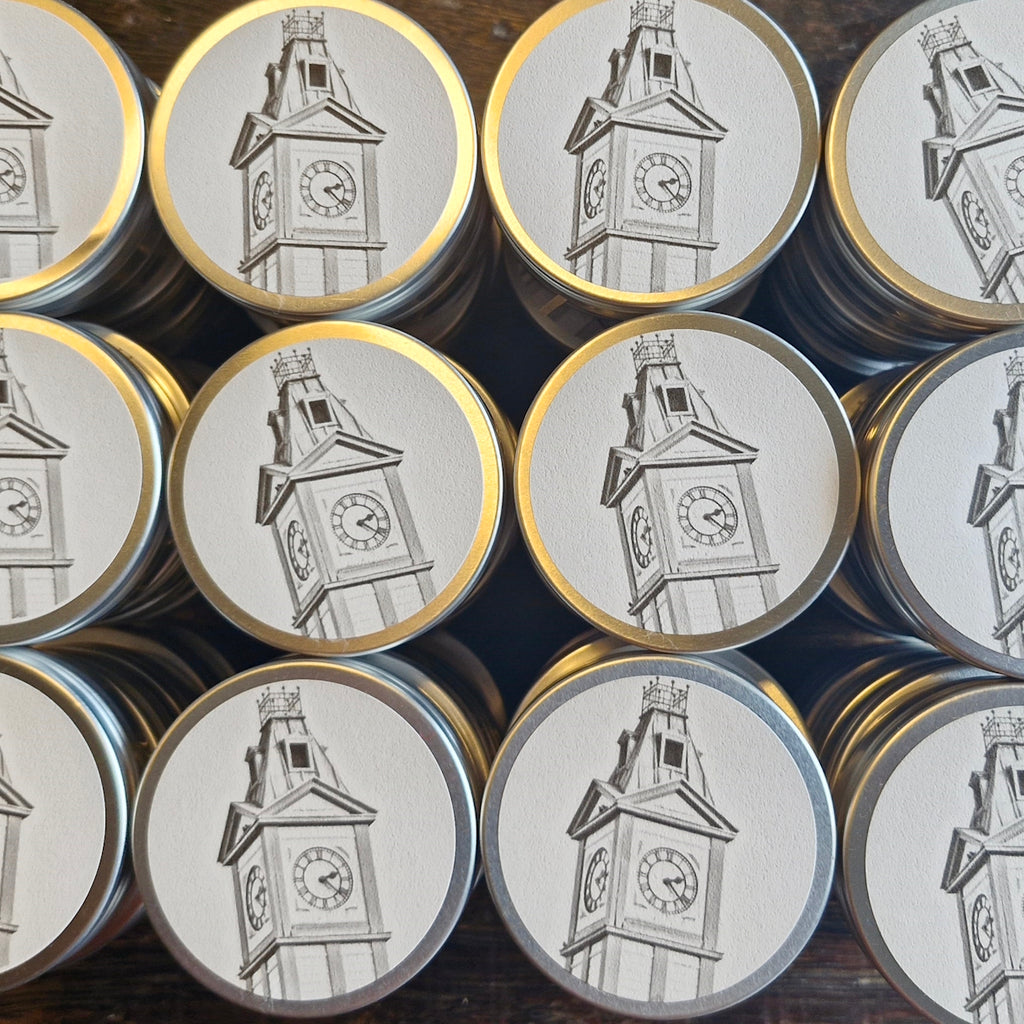 Collection of round silver tins with clock tower design on lids.