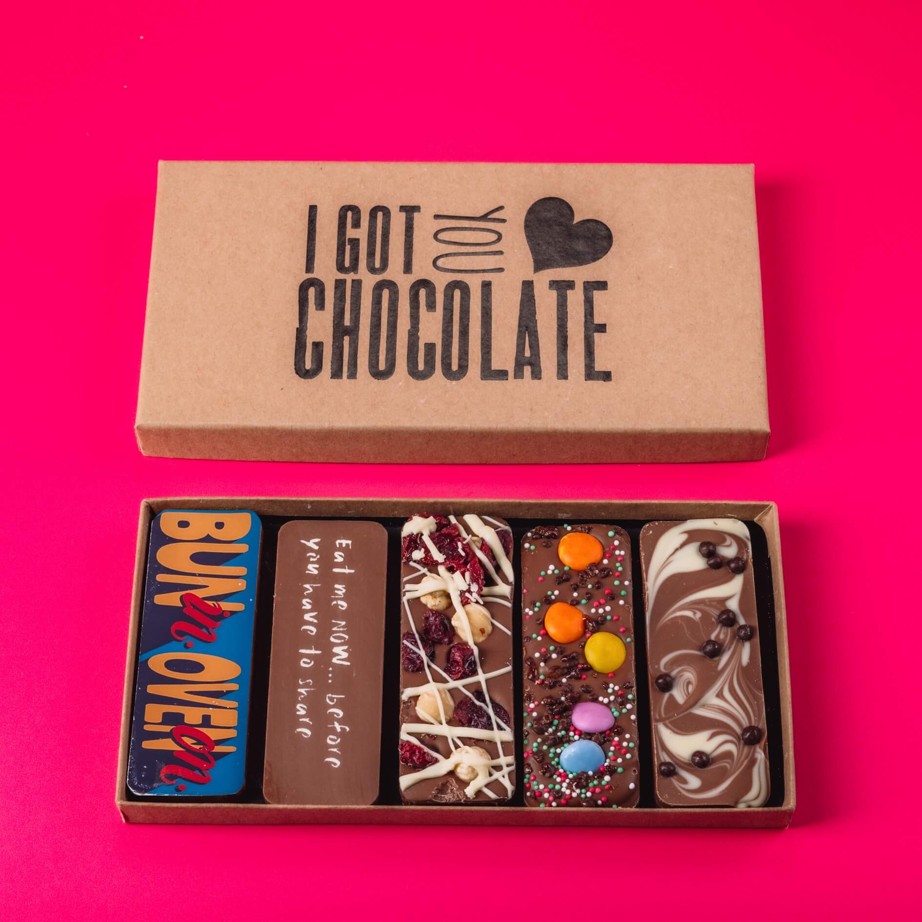A chocolate gift box containing five handmade chocolate bars, including one that says “Bun in. Oven on.” – a fun gift idea for expecting mothers with taste and a sense of humour.