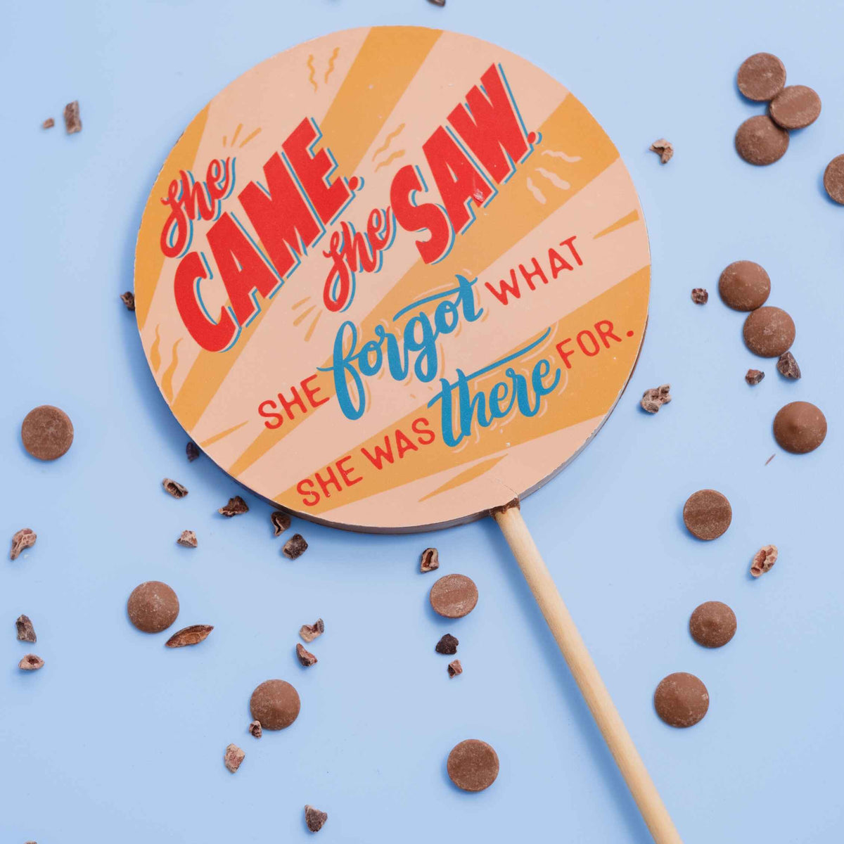 Gift ideas for her… you couldn’t go far wrong with these funny perimenopause chocolate lollipops, shown here surrounded by chocolate buttons on a blue background