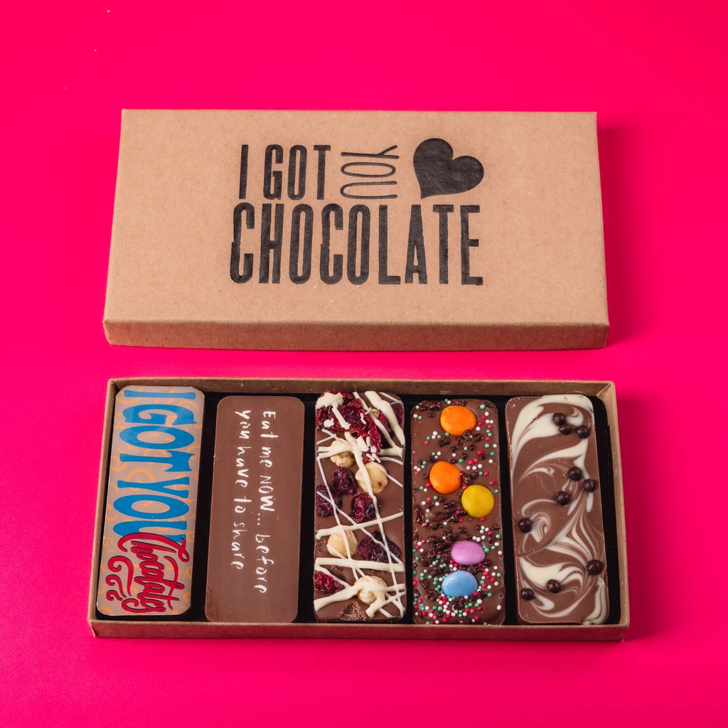 Open cardboard gift box labelled “I Got You Chocolate” containing five handmade chocolate bars with playful messages or topping – makes fun and tasty sorry gifts for her.