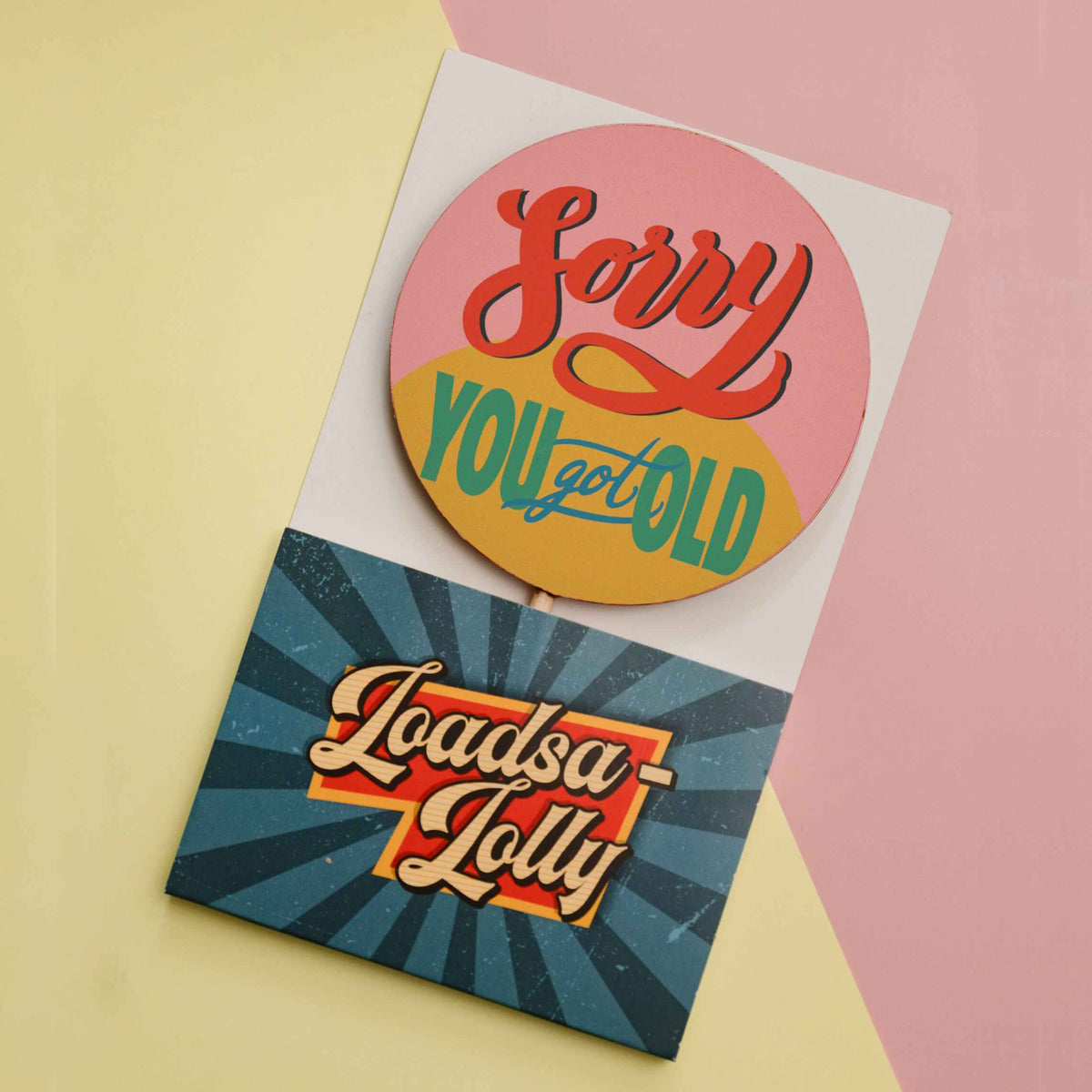Our cheeky birthday chocolate lollipop shown in it's custom, vintage themed 'Loadsa-Lolly' packaging