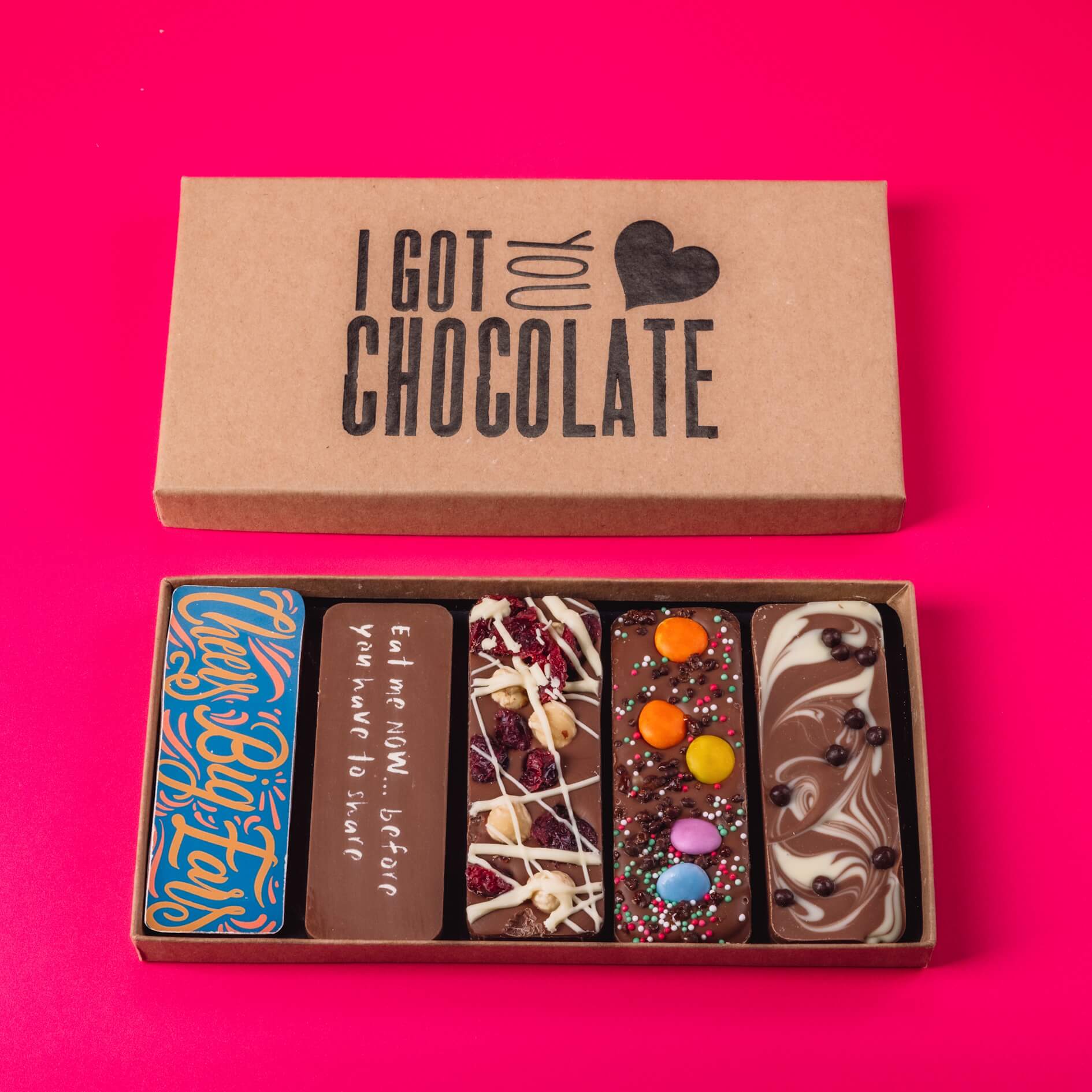 Open “I Got You Chocolate” gift box on a bright background, featuring five handmade chocolate bars with playful messages and delicious toppings – a cheeky and tasty chocolate selection box.