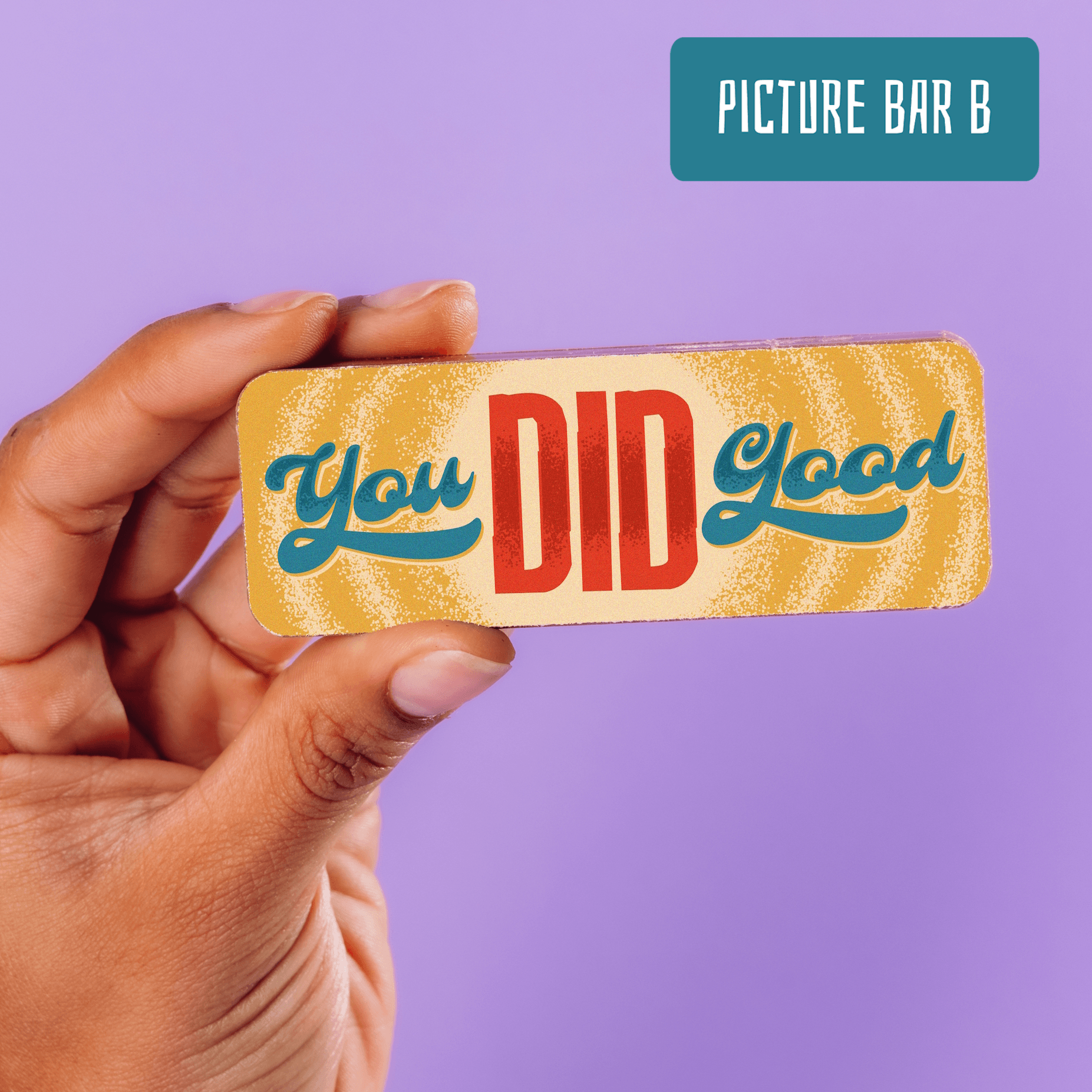 A hand holds a rectangular chocolate that reads 'You DID Good' in blue and red lettering.  Part of the Thank You gift chocolate selection box.