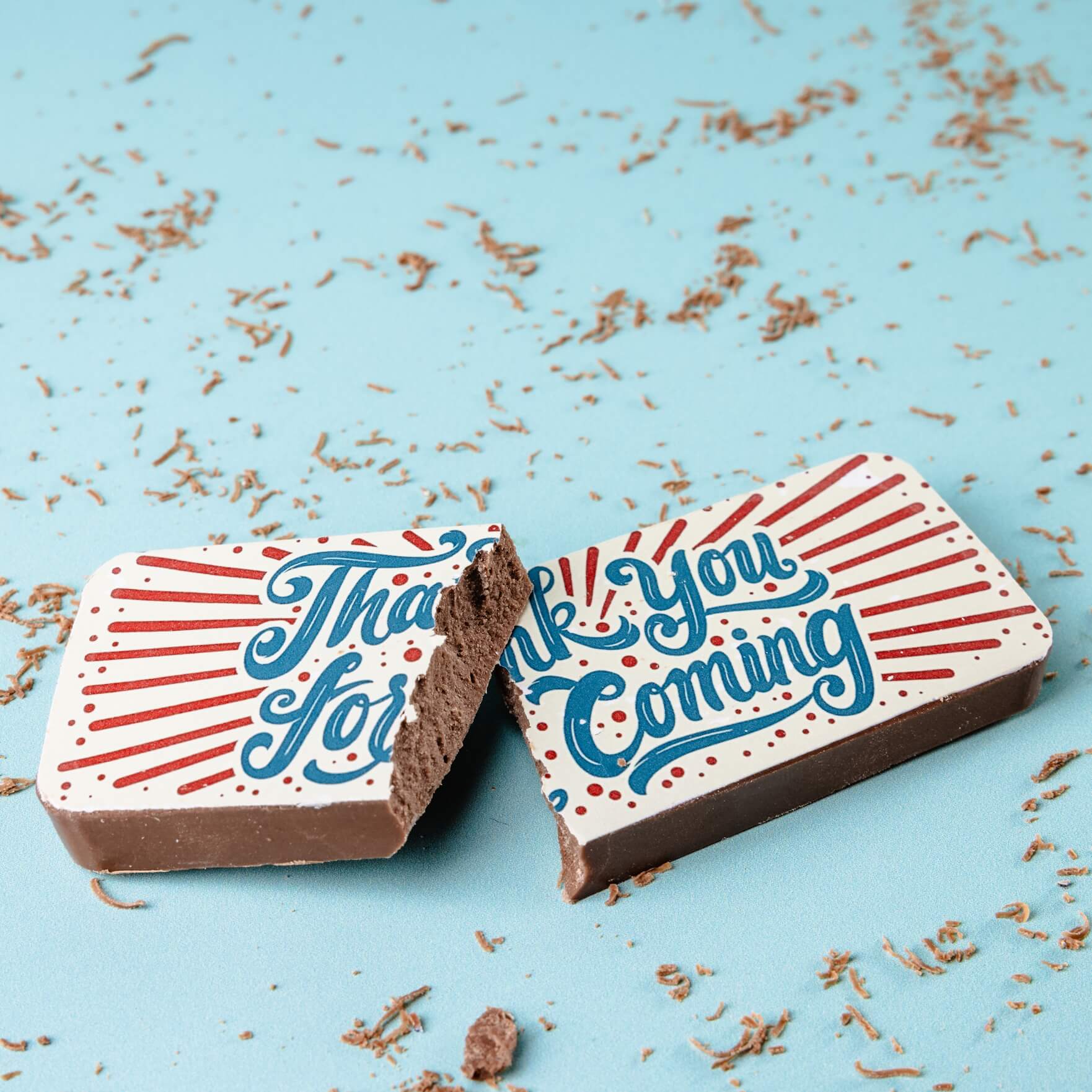 A colourful 'Thank you for coming' chocolate favour broken to show the milk chocolate centre