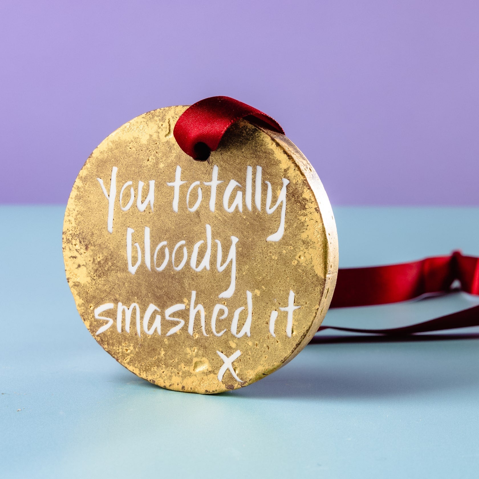 Fairtrade chocolate congratulations medal, standing up on its side and showing off its sparkly finish. An exam congratulations gift to make all the hard work worthwhile!