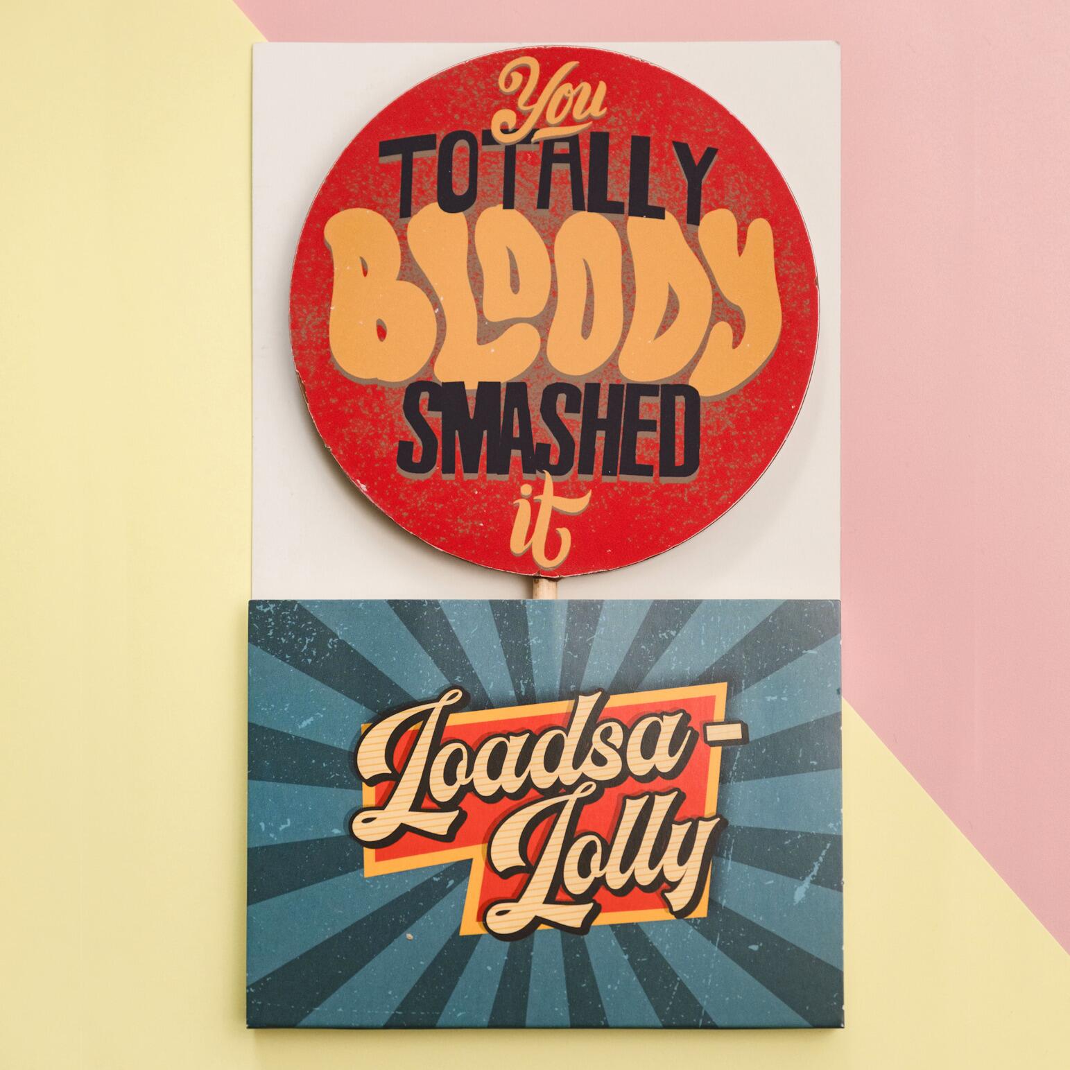 A giant chocolate picture lolly shown in its custom 'Loadsa-Lolly' packaging