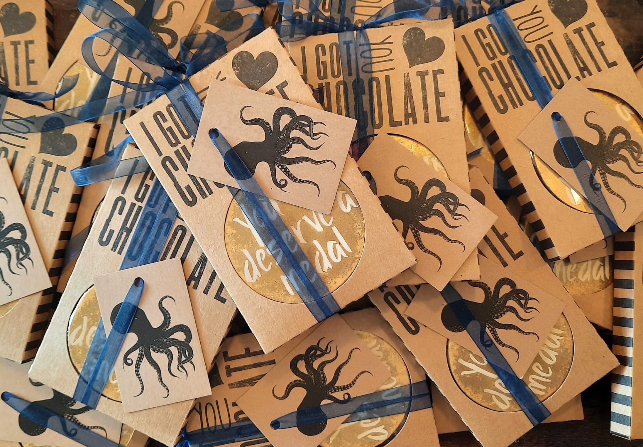 A pile of 'You deserve a medal' chocolate medals for a corporate order - sent out on behalf of the client with personalised gift tags