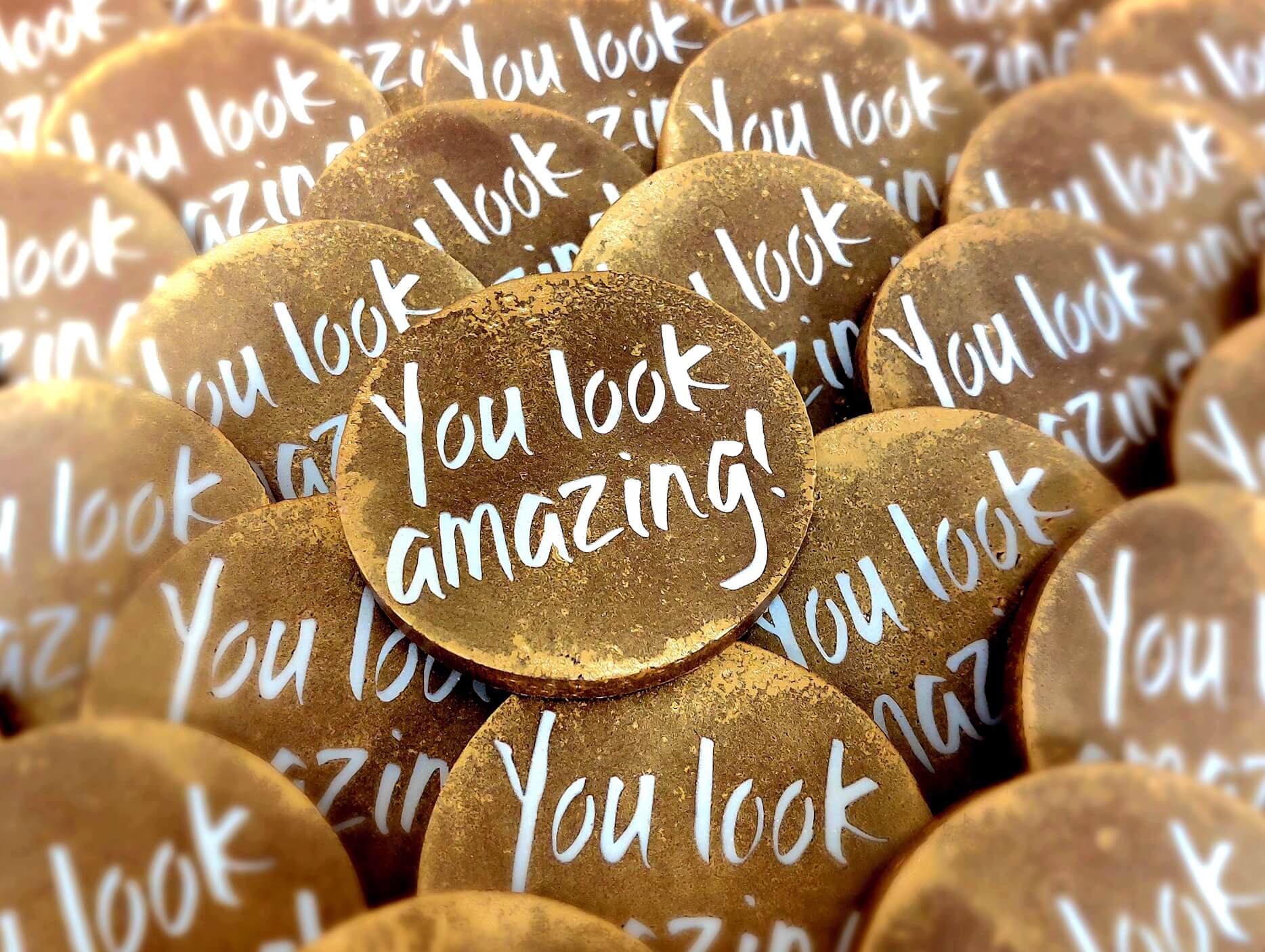 A shot of some custom 'You look amazing!' chocolate medals in production for a corporate customer