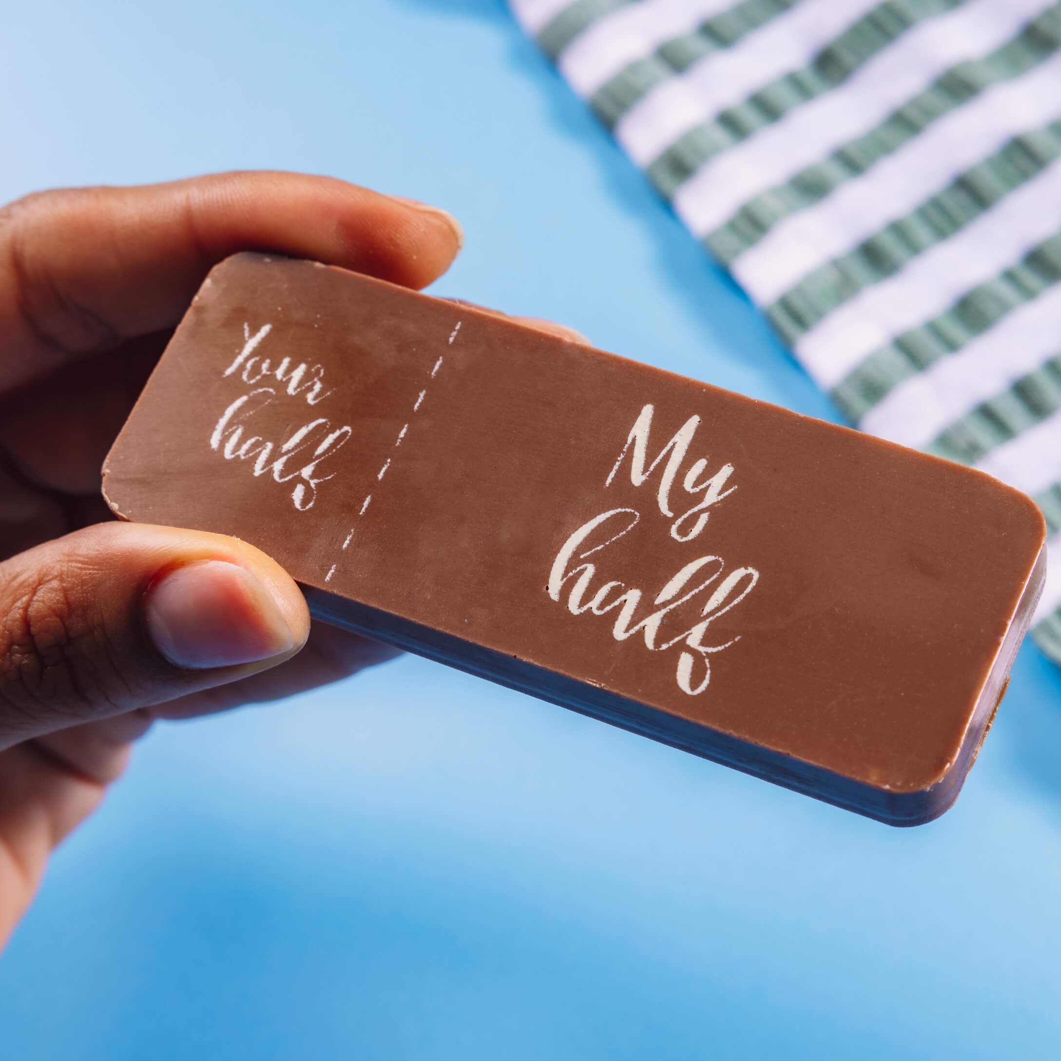 A fair trade milk chocolate bar decorated with a message in cocoa butter dividing 'Your half' (small) and 'My half' (big)