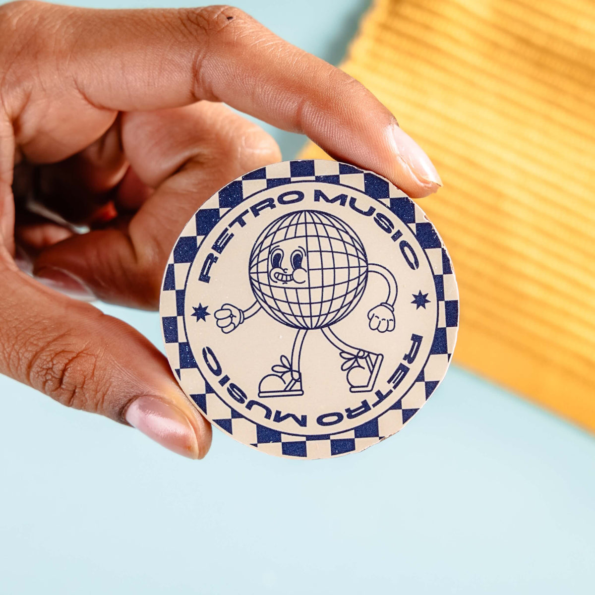 Hand holding a customised 'Retro Music' branded chocolate disc