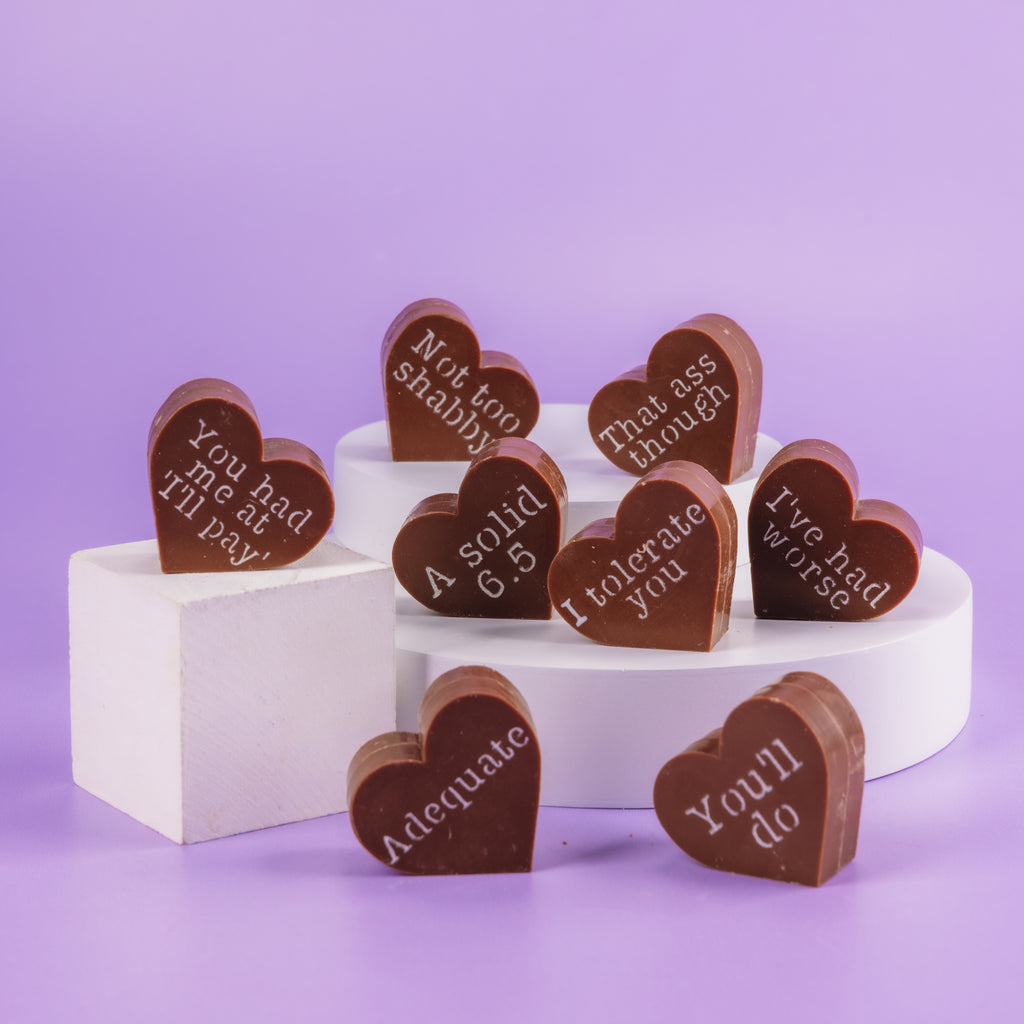 Heart-shaped chocolates with witty, brutally honest messages— a funny Valentine’s gift for men who prefer sarcasm over sweet nothings