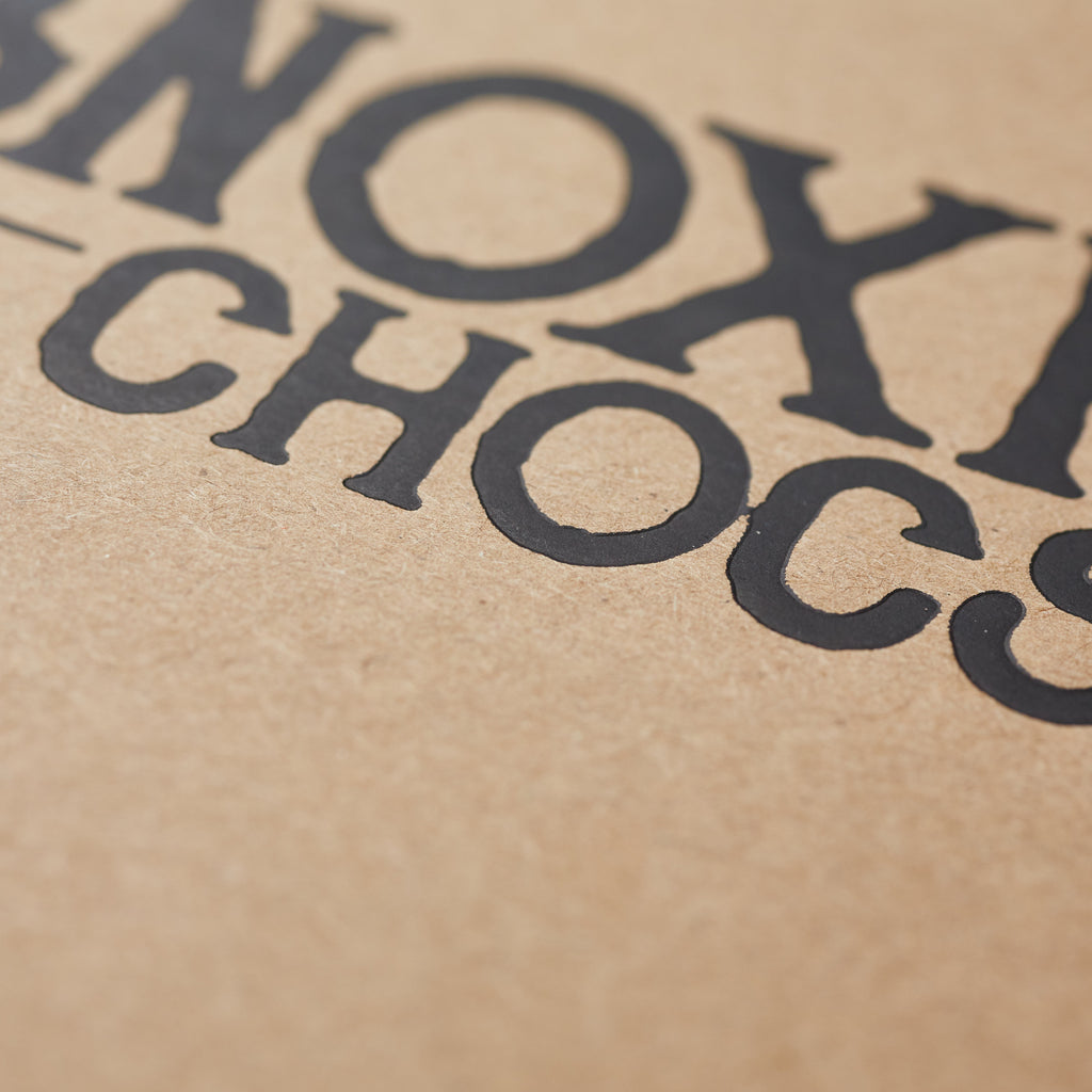 An extreme close up of the lettering on the Obnoxious Chocs gift packaging