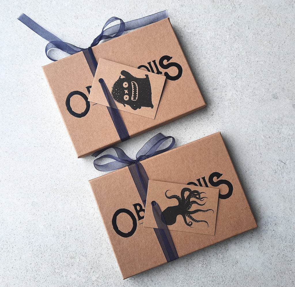 Our choice of octopus or monster gift tags attached with blue ribbon to a box of Obnoxious Chocs