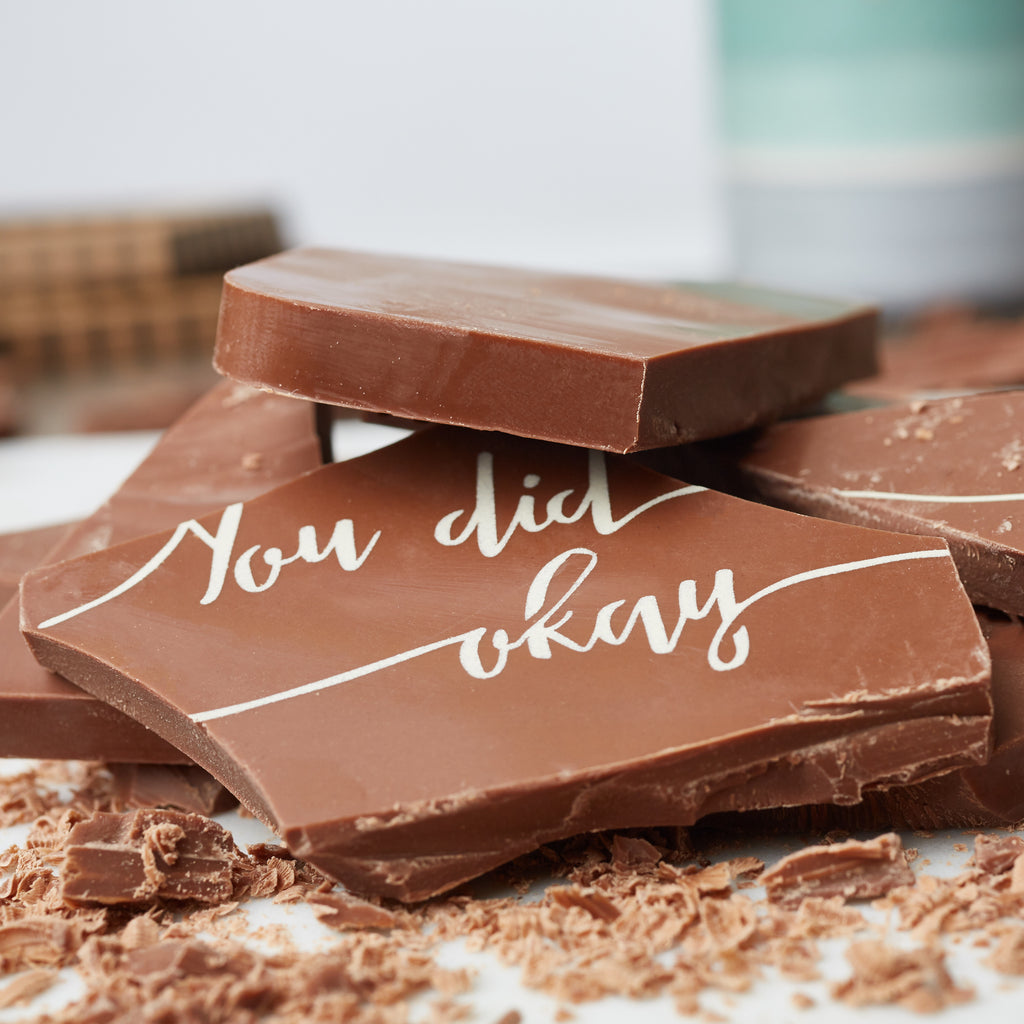 Broken pieces of 'You did okay' Belgian chocolate bar piled in close up