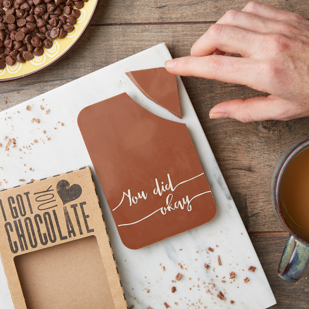 Milk chocolate bar pictured with a 'You did okay' message and a chunky corner being broken off