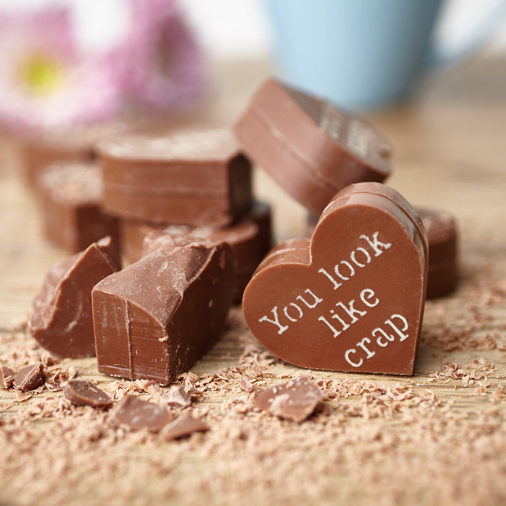 A close up of a 'You look like crap' message on a chunky Belgian milk chocolate heart