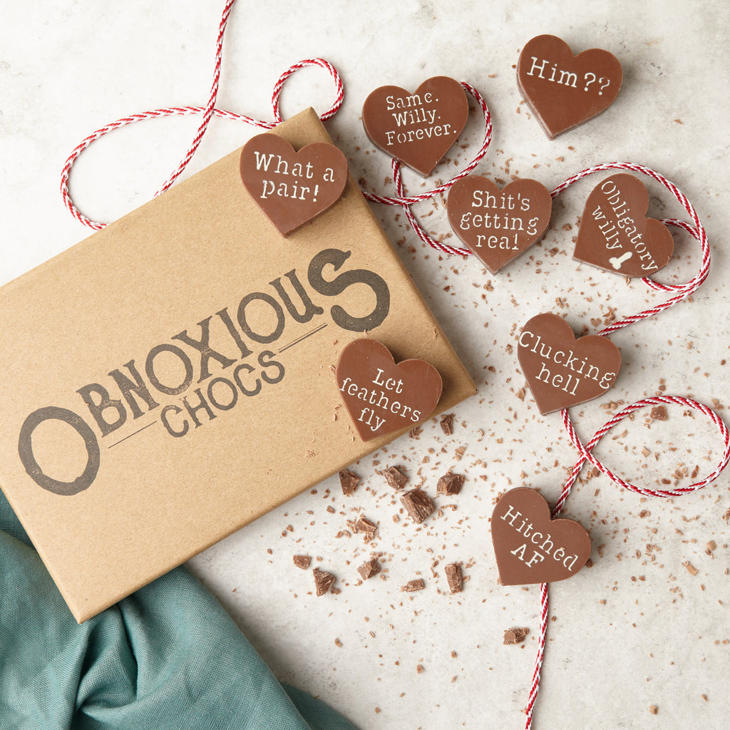 View of all eight Obnoxious Chocs chocolate hearts with their funny Hen Night messages, which include:  'What a pair!'; 'Same. Willy. Forever.'; 'Him??'; 'Shit's getting real!', 'Obligatory willy'; 'Let feathers fly'; 'Clucking hell'; and 'Hitched AF'.